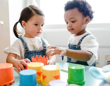 two toddlers playing at a table