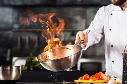 Chef holding pan with fire in it