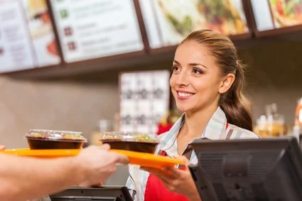 Fast food worker passing tray of food