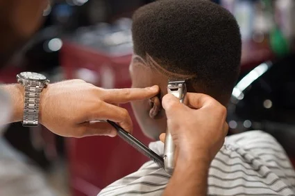 boy getting haircut in barber chair